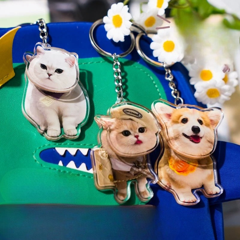 Three cat-shaped keychains on a colorful background